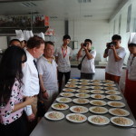Dr Tempest-Mogg gets ready to try a dish prepared by students