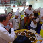 Dr Tempest-Mogg tries a dish while the students wait in trepidation