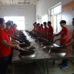 Culinary students practising how to stir fry using a wok